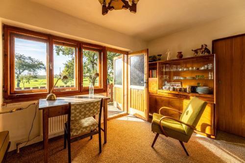 a kitchen with a desk and a chair and windows at Chalupa u Šrámků - rodinné ubytování v Moravském krasu in Bousín