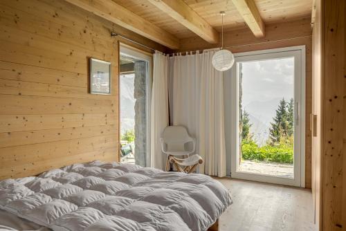 sypialnia z łóżkiem i dużym oknem w obiekcie Rupicapra w mieście Bettmeralp