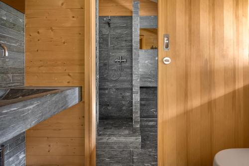a bathroom with a walk in shower next to a wooden door at Rupicapra in Bettmeralp