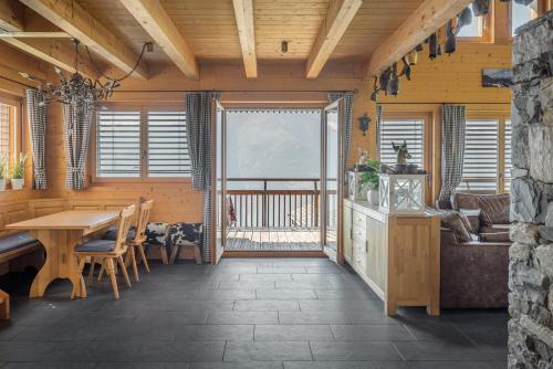 a dining room with a table and a balcony at Laackerhof in Bettmeralp
