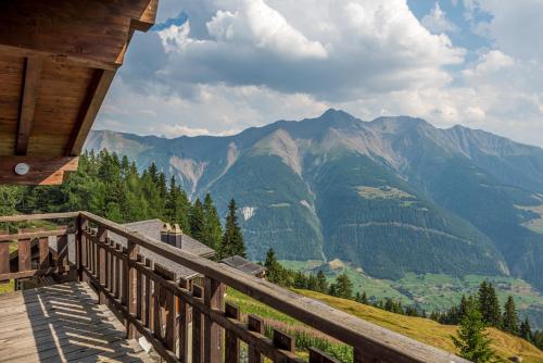 a wooden balcony with a view of mountains at Rupicapra in Bettmeralp