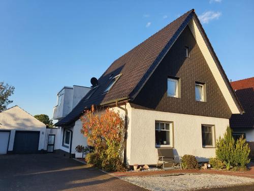 una casa con techo negro y una silla en la entrada en Haus KanaleGrande, en Haltern