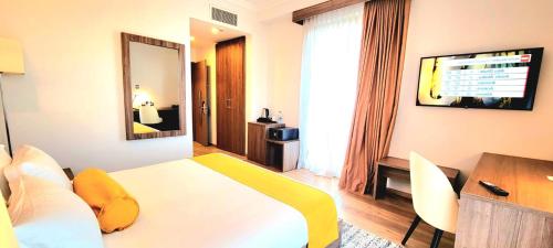 a bedroom with a bed and a table and a mirror at TH BonRoyal Hotel in Addis Ababa
