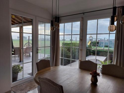 ein Esszimmer mit einem Tisch und einem großen Fenster in der Unterkunft Florentinus met hottub, afgesloten tuin en overdekt terras in Veurne