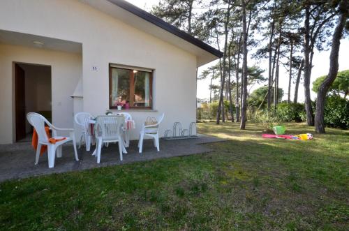 un patio con tavolo e sedie in un cortile di Villaggio Le Palme a Lignano Sabbiadoro