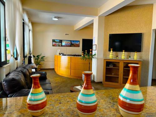three colorful vases sitting on a table in a living room at Hotel São Pedro in São Pedro