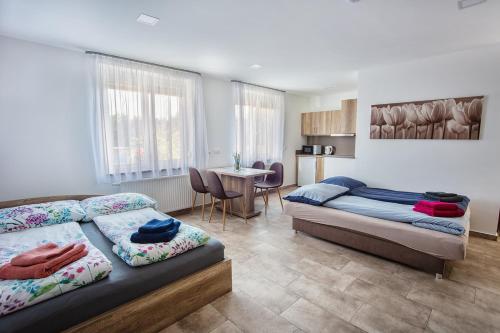 1 dormitorio con 2 camas y mesa. en Mona Apartman, en Sárvár
