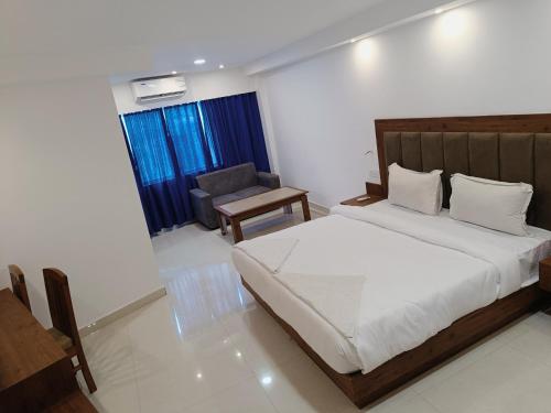 a bedroom with a bed and a chair in it at Sambodhi Retreat in Dhanbād