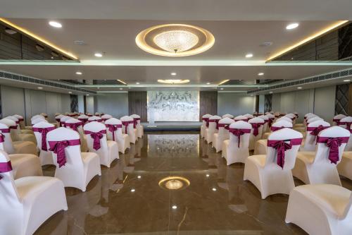 a room with rows of chairs with purple bows at Hotel Parkelite in Gannavaram