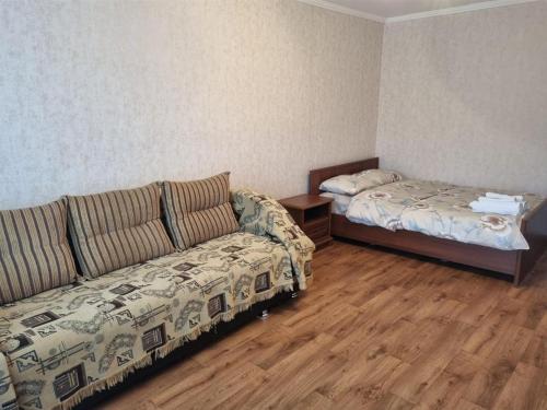 ein Wohnzimmer mit einem Sofa und einem Bett in der Unterkunft 1-комн центр, 45 квартал, Вокзал, Бухар-Жырау 69 in Qaraghandy