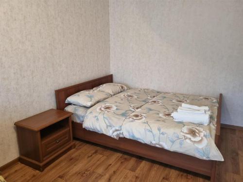1 dormitorio con 1 cama y mesita de noche con toallas en 1-комн центр, 45 квартал, Вокзал, Бухар-Жырау 69 en Karagandá