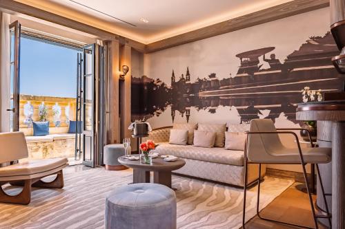 a living room with a couch and a large window at Iniala Harbour House in Valletta