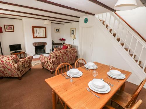 a dining room with a table and a living room at Ty Canol in Mathry