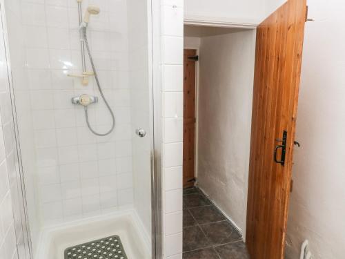 a shower with a glass door in a bathroom at Ty Canol in Mathry