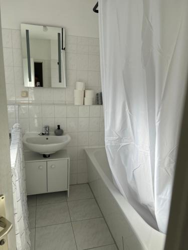 een badkamer met een wastafel, een bad en een spiegel bij Stylische Ferienwohnung gratis WIFI & Netflix nähe Bahnhof in Zwickau