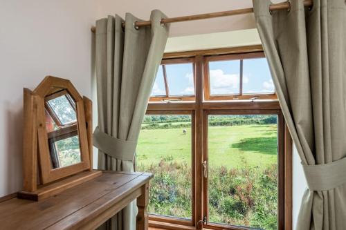 ein Fenster in einem Zimmer mit einem Spiegel und einem Fenster mit Vorhängen in der Unterkunft The Granary in Barnstaple