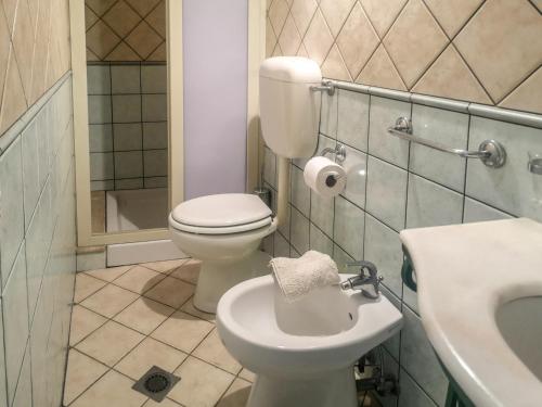 a bathroom with a white toilet and a sink at Camping Almoetia in Calatabiano