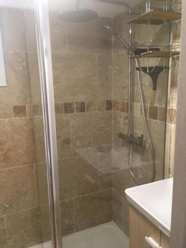 une douche avec une porte vitrée dans une salle de bain dans l'établissement Charmant appartement refait à neuf vue mer, à Porticcio