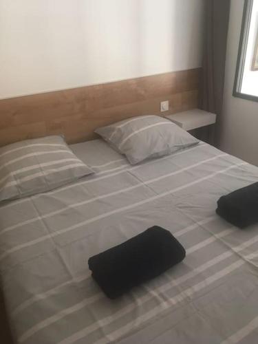 un grand lit blanc avec deux oreillers dessus dans l'établissement Charmant appartement refait à neuf vue mer, à Porticcio