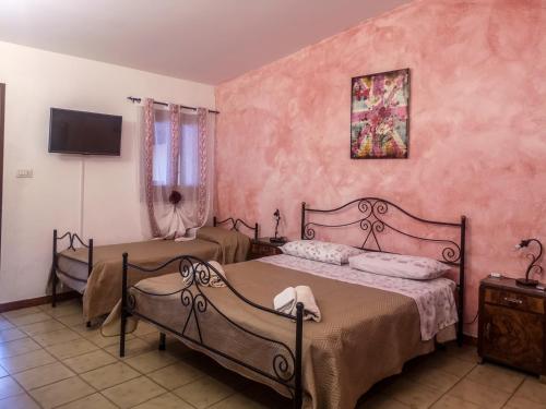 1 dormitorio con 2 camas y TV en la pared en Camping Almoetia, en Calatabiano