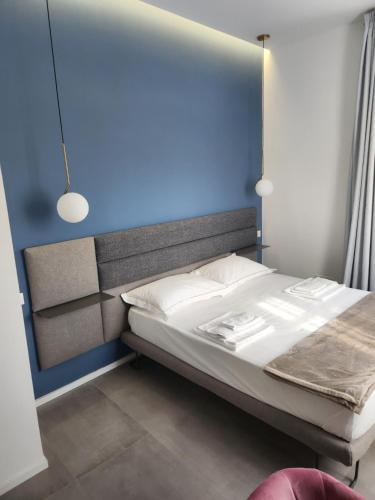 a bedroom with a large bed with a blue wall at Dadà Suites in Catania