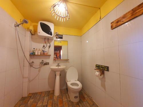 a bathroom with a toilet and a tv on the wall at La Beauté Sa Pa in Sa Pa