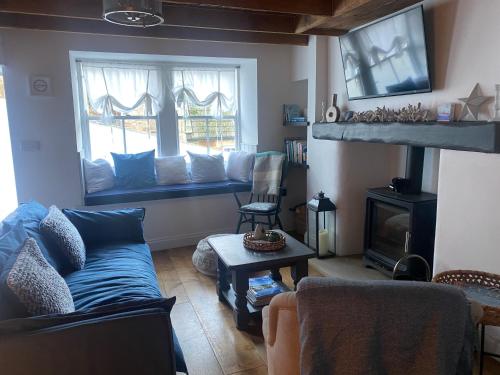 ein Wohnzimmer mit einer Couch und einem Fenster in der Unterkunft Shrimp Cottage - 3 bed renovated cottage with stunning sea views in Staithes
