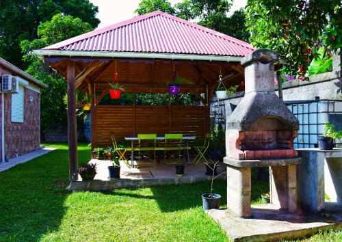 a wooden gazebo with a table and a fireplace at Jardin des Sucriers in Trois-Rivières