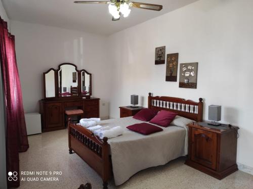 1 dormitorio con cama con almohadas rojas y espejo en D'Ambrogio Guest House, en Rabat