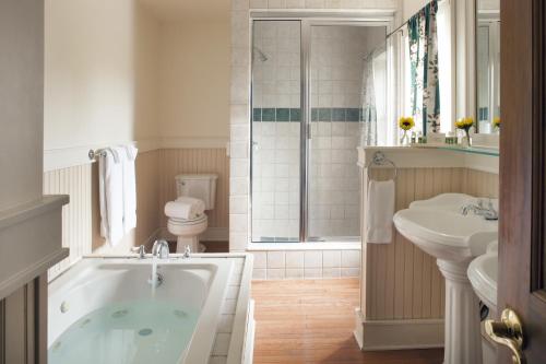 a bathroom with a tub and a sink and a toilet at Friends Lake Inn in Chestertown