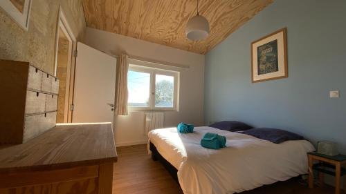 une chambre avec deux lits et une fenêtre dans l'établissement Maison de charme avec jardin et terrasse, à Camblanes-et-Meynac