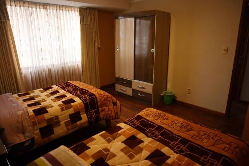 - une chambre avec 2 lits et une commode dans l'établissement Departamentos independientes en Zona central, à La Paz