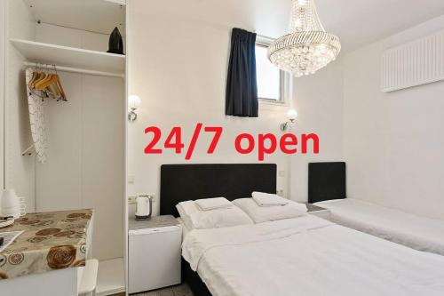 a white bedroom with a open sign on the wall at Hotel-Chao NL 24 hours open in Utrecht