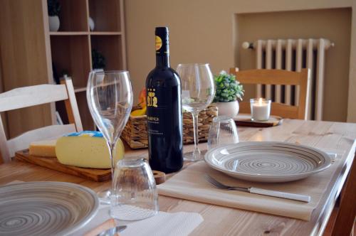 un tavolo con una bottiglia di vino e bicchieri da vino di Le Case di Sonia DEL CORSO CIV 25 Fucecchio a Fucecchio
