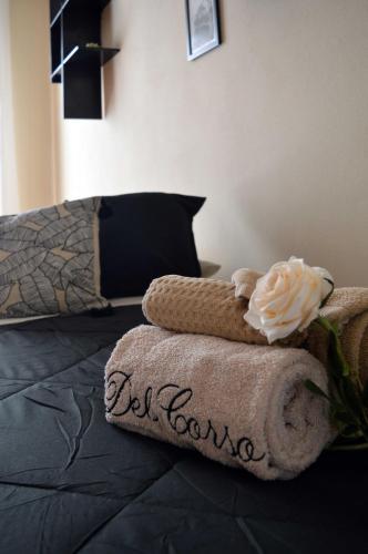 a bed with a pile of towels on it at Le Case di Sonia DEL CORSO CIV 25 Fucecchio in Fucecchio