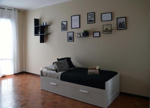 un letto in una camera con immagini appese al muro di Le Case di Sonia DEL CORSO CIV 25 Fucecchio a Fucecchio