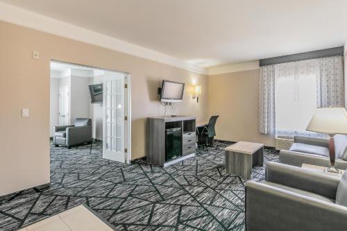 a hotel room with a couch and a tv at La Quinta by Wyndham Granbury in Granbury