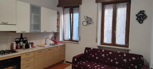 a kitchen with a couch and a kitchen with windows at Casa Emily Verona in Verona