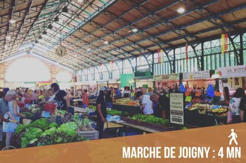 a farmers market with a crowd of people in a building at Black Cognac in Joigny