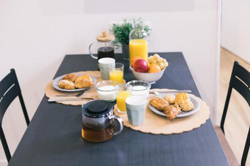 a black table with plates of food and glasses of orange juice at Black Cognac in Joigny