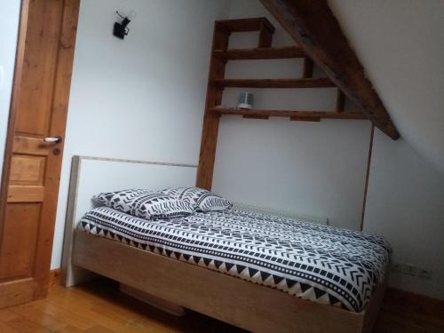 a bedroom with a bed with a ladder on the wall at La montagne in Le Bourg-dʼOisans