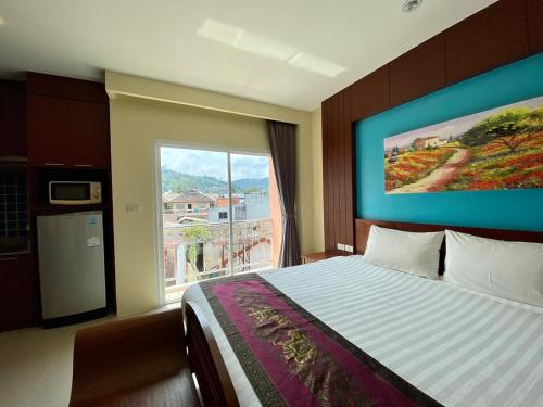 sypialnia z łóżkiem i dużym oknem w obiekcie Baan Sudarat Hotel w Patong Beach