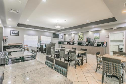 a restaurant with tables and chairs and a bar at La Quinta by Wyndham Granbury in Granbury
