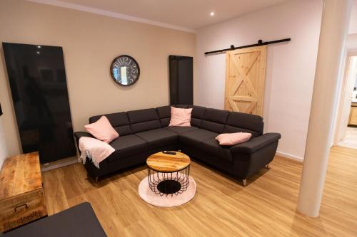 a living room with a black couch and a table at Urlaubsoase Moselglück in Kröv