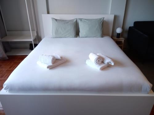 een slaapkamer met een wit bed en handdoeken bij Oporto Batalha Nice View Flat in Porto
