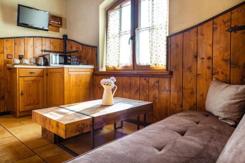 ein Wohnzimmer mit einem Tisch und einer Blumenvase darauf in der Unterkunft Zajazd Przystocze - Bałtowski Kompleks Turystyczny in Bałtów