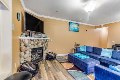 a living room with a blue couch and a fireplace at Oceanfront Contemporary in Lincoln City