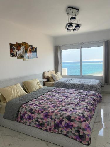 a bedroom with a bed and a view of the ocean at Blue Whale Hurghada Beach Front Apartments City Centre in Hurghada