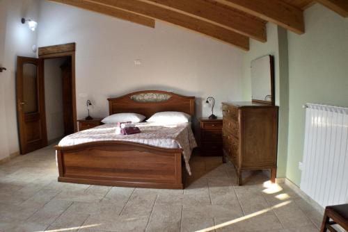 um quarto com uma cama de madeira e uma cómoda em b&b CASCINA SORTINA Country House em Ozzano Monferrato