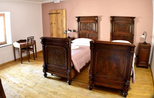 a bedroom with two wooden beds and a table at b&b CASCINA SORTINA Country House in Ozzano Monferrato